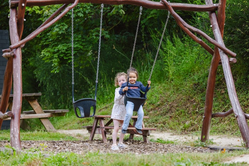 Les Balançoires une petite fille se fait pousser par une autre petite fille